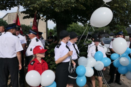 Grupa osób trzymająca biało - niebieskie balony