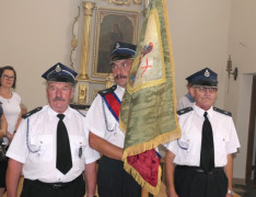 Strażacy. Jeden z nich trzyma sztandar 