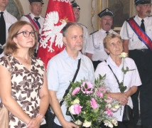 Dwie kobiety i mężczyzna. Mężczyzna trzyma w ręku kwiaty