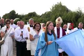 Uczestnicy procesji. W grupie osób widoczny duchowny 