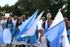 Uczestnicy procesji. Na pierwszym planie widoczne biało-niebieskie flagi