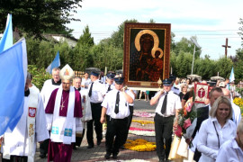 Strażacy niosą obraz Matki Bożej. Otacza ich grupa osób