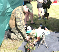 Mężczyzna i chłopiec. Chłopiec próbuje swoich sił w strzelaniu z karabinu 