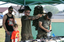 Mężczyźni i chłopiec przy stoisku militarnym 