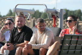 Grupa osób siedząca na ławce 