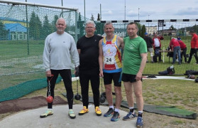 Czterej panowie w strojach sportowych stoją obok siebie 