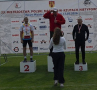 Trzej zawodnicy stoją na podium 