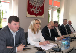 Osoby siedzące za stołem prezydialnym. Trwa sesja rady gminy