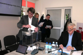 Mężczyzna podczas wrzucania karty do głosowania do urny