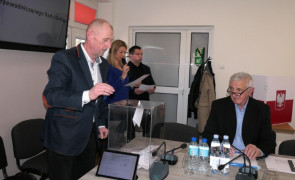 Mężczyzna podczas wrzucania karty do głosowania do urny