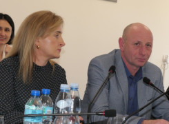 Kobieta i mężczyzna siedzą obok siebie. Trwają obrady rady gminy