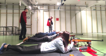 Kobieta strzela z broni na strzelnicy sportowej