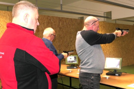 Dwaj mężczyźni strzelają na strzelnicy z broni krótkiej 