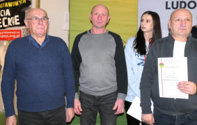 Trzej mężczyźni i kobieta. Jeden z mężczyzn trzyma w ręku dyplom 