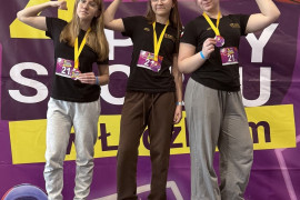 Trzy dziewczyny stoją obok siebie. Wszystkie mają medale na piersiach 