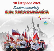Grupa osób w biało-czerwonych strojach. Osoby biegną. Widać powiewające biało-czerwone flagi