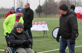 Trzej mężczyźni. Jeden z nich siedzi na wózku inwalidzkim 