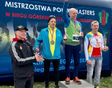 Czterej mężczyźni stoją obok siebie. Trzej z nich znajdują się na medalowym podium 