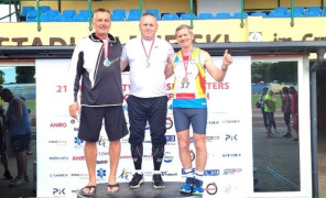 Trzej mężczyźni na podium. Pierwszy z lewej Piotr Płoskoński