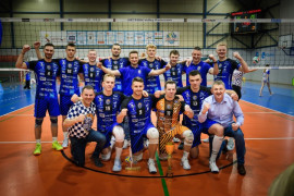 Grupa mężczyzn: siatkarze i osoby wspierające w geście triumfu 
