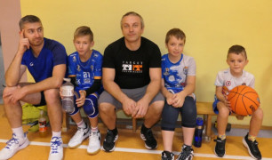 Dorośli i dzieci siedzą obok siebie 