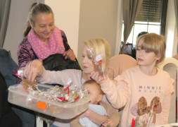 Dwie kobiety i dwoje dzieci. Jedna z kobiet częstuje pierniczkami