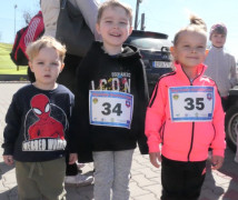 Dwie dziewczynki i chłopiec w sportowych strojach stoją obok siebie 