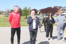 Dwaj mężczyźni stoją obok siebie. jeden z nich trzyma w ręku mikrofon 