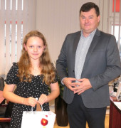 Mężczyzna i dziewczynka. Dziewczynka trzyma w ręku upominkową torbę 