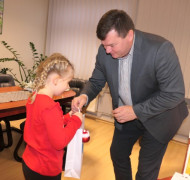 Mężczyzna wręcza dziewczynce prezent 
