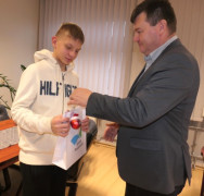 Mężczyzna wręcza chłopcu nagrodę 