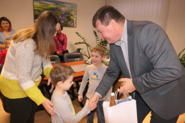Dwaj chłopcy w towarzystwie mamy odbierają prezent