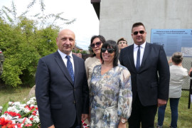  Grupa osób odświętnie ubranych na tle obelisku znajdującego się w Kocierzowach, a poświęconemu żołnierzom AK