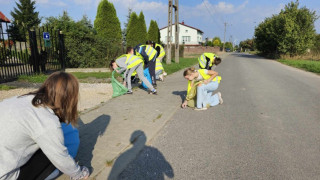 Młodzież podczas sprzątania świata - ubrana jest w odblaskowe kamizelki i wyposażona w worki na odpady