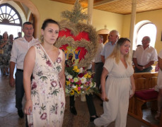Do kościoła wnoszony jest wieniec dożynkowy 