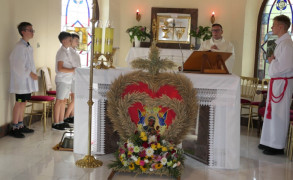 Ołtarz w kościele. Przed ołtarzem znajduje się dożynkowy wieniec 