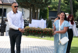 Kobieta i mężczyzna niosą wieniec dożynkowy 