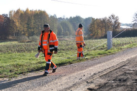 Droga przygotowana do remontu. Widoczni dwaj pracownicy w pomarańczowych strojach 