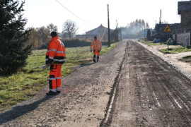 Droga w trakcie remontu. Widoczni robotnicy w pomarańczowych strojach 