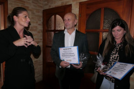Trzy osoby stojące obok siebie: dwie kobiety i mężczyzna. Kobieta i mężczyzna trzymają w ręku dyplomy 