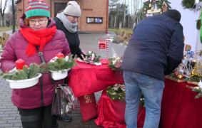 Kobieta trzyma w rękach dwa stroiki świąteczne 