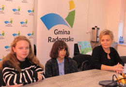 Kobieta i dwójka dzieci siedzą przy stole 