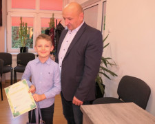 Mężczyzna i chłopiec. Chłopiec trzyma w ręku dyplom