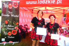 Panie w kolorowych strojach na tel stoiska wystawienniczego 