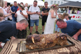 Dwaj mężczyźni wykładają pieczonego dzika