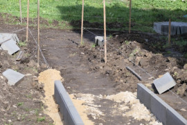 Chodni w budowie. Widoczny piach, krawężniki 