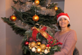Kobieta prezentuje własnoręcznie zrobiony stroik świąteczny