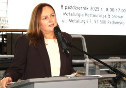 Kobieta stojąca przy mównicy 