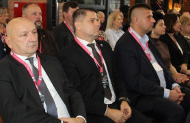 Trzej mężczyźni siedzą podczas spotkania obok siebie 