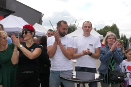 Osoby stoją obok siebie i biją brawo 